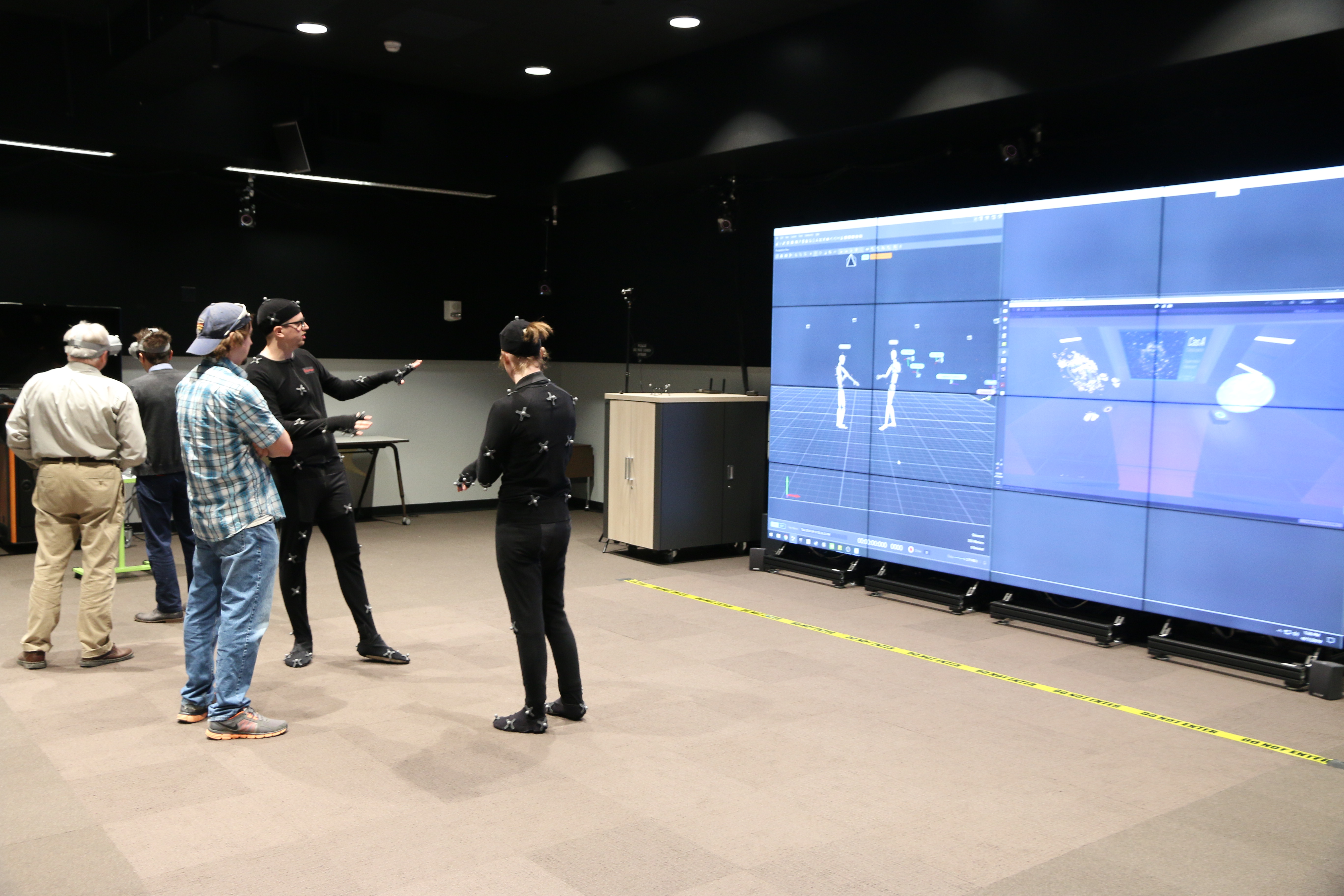 Envision Center students demonstrating the motion capture suits that track a user’s movement and insert a representation of the user into the virtual environment